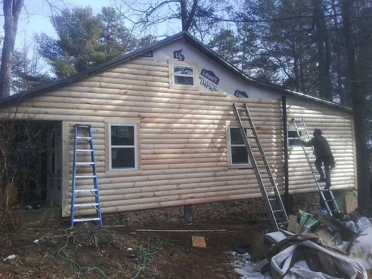 Ladders set against fresh log siding during an exterior remodel in Moore Haven