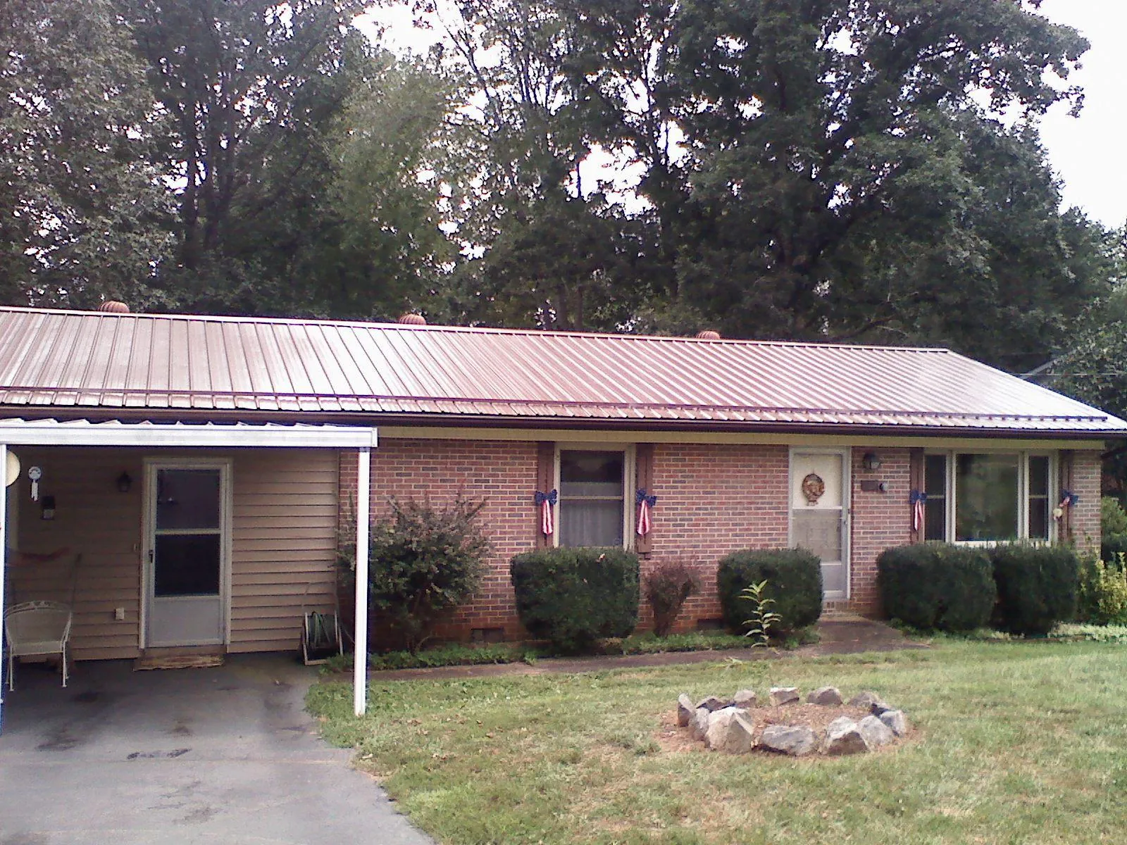 Bronze metal roof and carport on a brick ranch home — Roof Repair work by our crew in Moore Haven